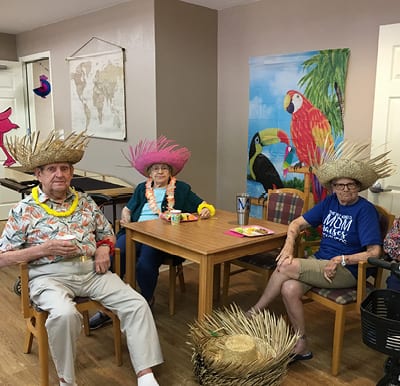 Senior gathered around a table at a themed paradise party in North Richland Hills, Texas.