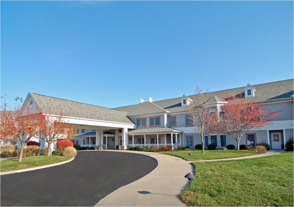 Front entrance of a senior living facility in Rochester, Indiana with circular driveway and covered entrance..