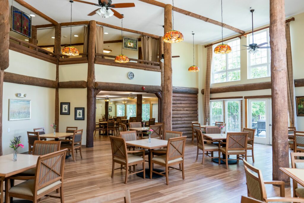 Rose Arbor and Wildflower Lodge dining room with soaring ceiling and wood exposed beams and columns at a senior living facility in Maple Grove, Minnesota.