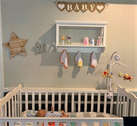 baby crib with baby doll inside along with baby decorations