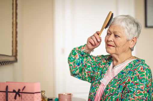 A senior woman brushing her hair